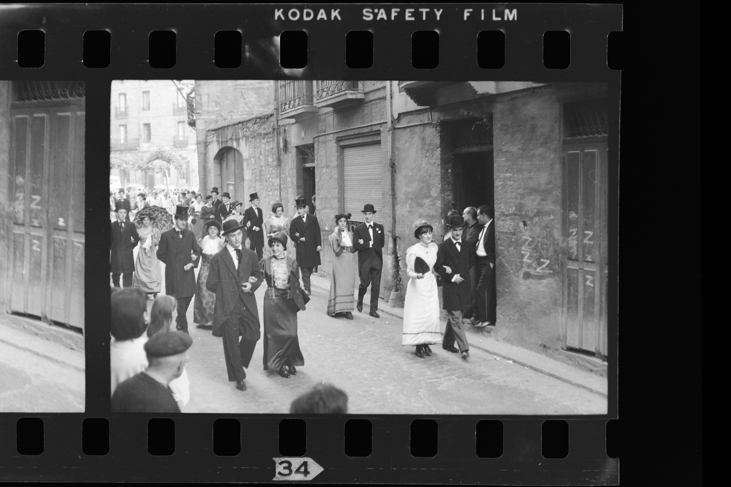 Parejas cogidas del brazo, elegantemente vestidas desfilando por la calle.  | Artxiboa